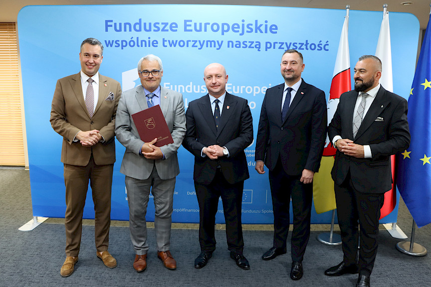 Przedstawiciele Zarządu Województwa Lubelskiego pozują do zdjęcia na ściance Funduszowej z beneficjentem projektu.