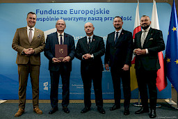Przedstawiciele Zarządu Województwa Lubelskiego pozują do zdjęcia na ściance Funduszowej z beneficjentem projektu.