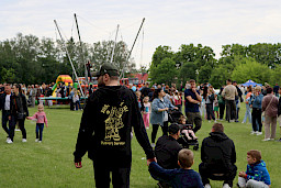 Tłum ludzi na pikniku, w tle trampolina