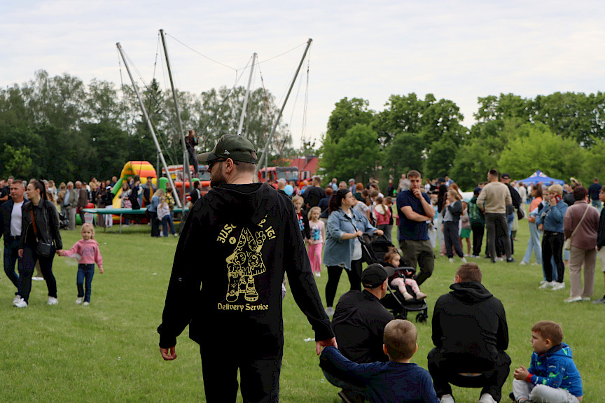 Tłum ludzi na pikniku, w tle trampolina