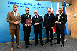 Przedstawiciele Zarządu Województwa Lubelskiego pozują do zdjęcia na ściance Funduszowej z beneficjentami projektu.