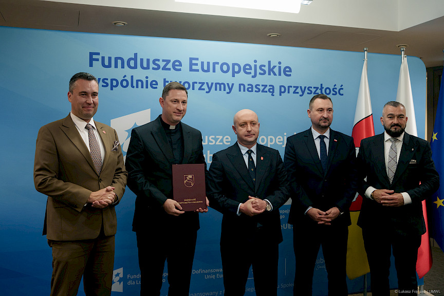Przedstawiciele Zarządu Województwa Lubelskiego pozują do zdjęcia na ściance Funduszowej z beneficjentami projektu.