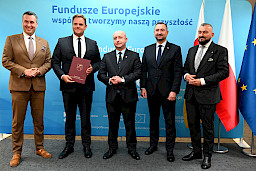 Przedstawiciele Zarządu Województwa Lubelskiego pozują do zdjęcia na ściance Funduszowej z beneficjentami projektu.