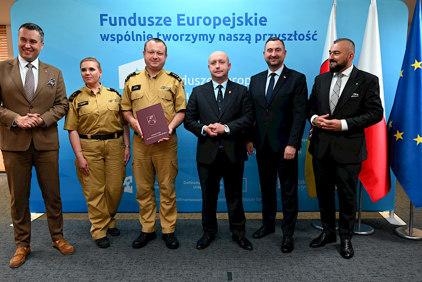 Przedstawiciele Zarządu Województwa Lubelskiego pozują do zdjęcia na ściance Funduszowej z beneficjentami projektu.