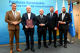 Przedstawiciele Zarządu Województwa Lubelskiego pozują do zdjęcia na ściance Funduszowej z beneficjentem projektu.