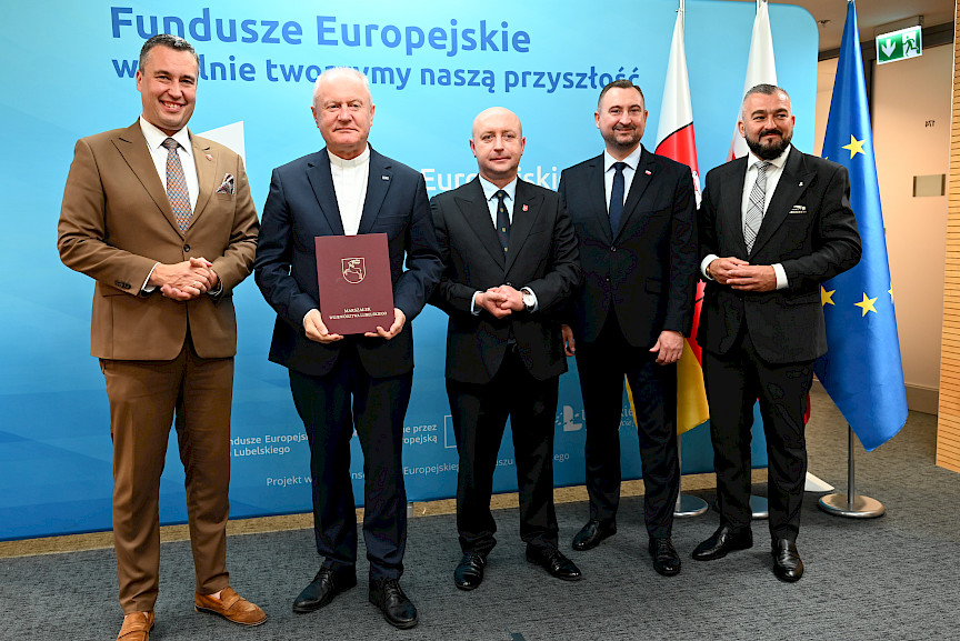 Przedstawiciele Zarządu Województwa Lubelskiego pozują do zdjęcia na ściance Funduszowej z beneficjentem projektu.