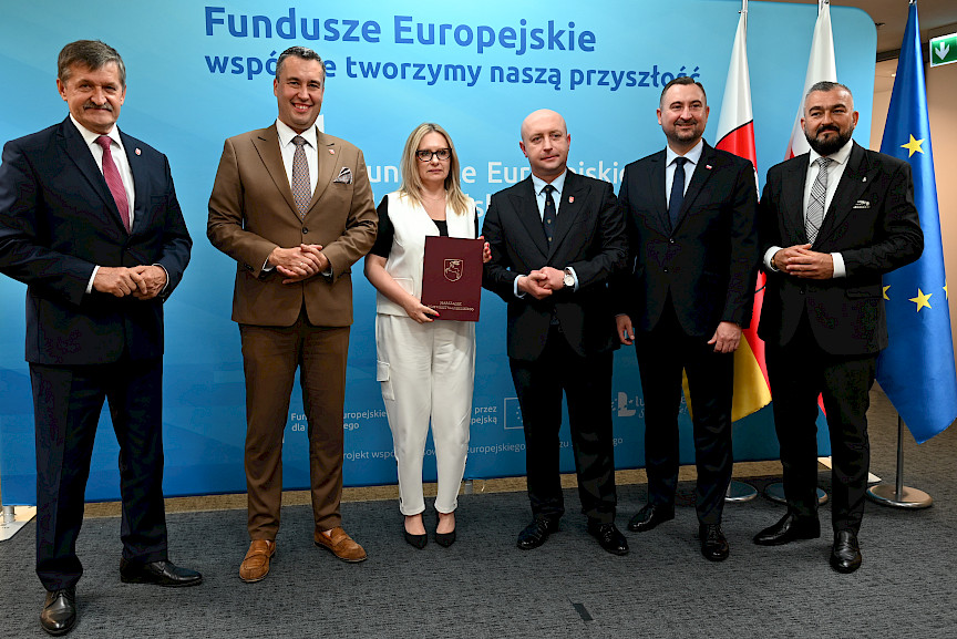 Przedstawiciele Zarządu Województwa Lubelskiego pozują do zdjęcia na ściance Funduszowej z beneficjentami projektu.