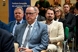 Ujęcie na kilka osób siedzących na widowni.