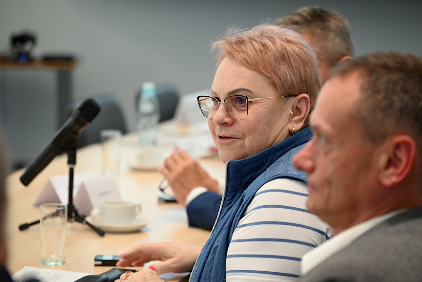 Ujęcie z bliska kobiety, uczestniczki posiedzenia.