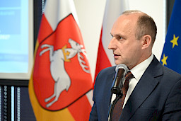 Ujęcie twarzy z bliska Dyrektora Departamentu Wdrażania Europejskiego Funduszu Rozwoju Regionalnego Andrzeja Danaja wypowiadającego się do mikrofonu.