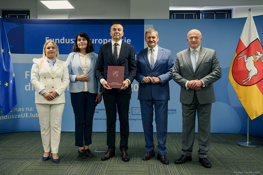 Dyrektor Departamentu Zarządzania Programami Regionalnymi Anna Brzyska oraz Marszałek Województwa Lubelskiego stoją ustawieni do zdjęcia z beneficjentami projektu.