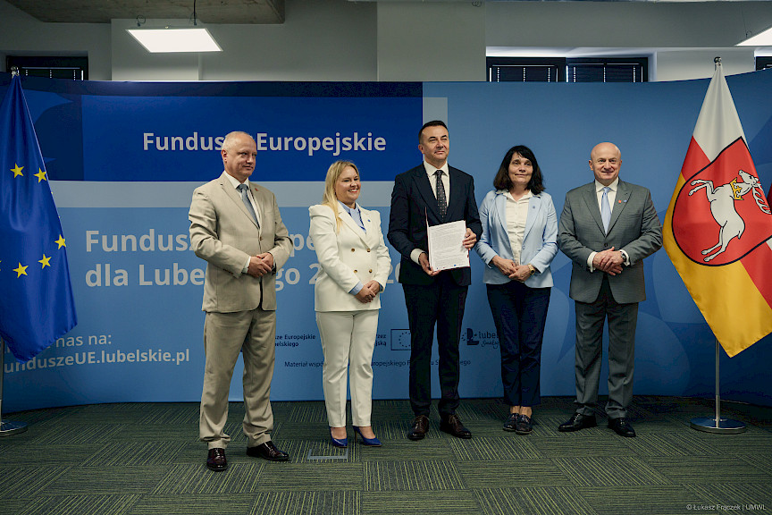 Marszałek Województwa Lubelskiego Jarosław Stawiarski, Dyrektor Anna Brzyska oraz Dyrektor LAWP Marek Neckier ustawieni są do zdjęcia z beneficjentem projektu.