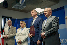Marszałek Województwa Lubelskiego Jarosław Stawiarski, Dyrektor Departamentu Zarządzania Programami Regionalnymi Anna Brzyska oraz Dyrektor LAWP Marek Neckier ustawieni są do zdjęcia z beneficjentem projektu.