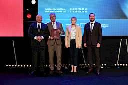 Marszałek Województwa Lubelskiego Jarosław Stawiarski oraz Wicemarszałek Marek Wojciechowski stoją z beneficjentami projektu, kobietą oraz mężczyzną.