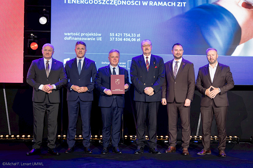 Marszałek Województwa Lubelskiego Jarosław Stawiarski z Wicemarszałkiem Markiem Wojciechowskim stoją z czterema beneficjentami projektu.