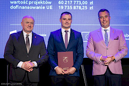 Marszałek Województwa Lubelskiego Jarosław Stawiarski wraz z Członkiem Zarządu Marcinem Szewczakiem stoją z beneficjentem projektu.