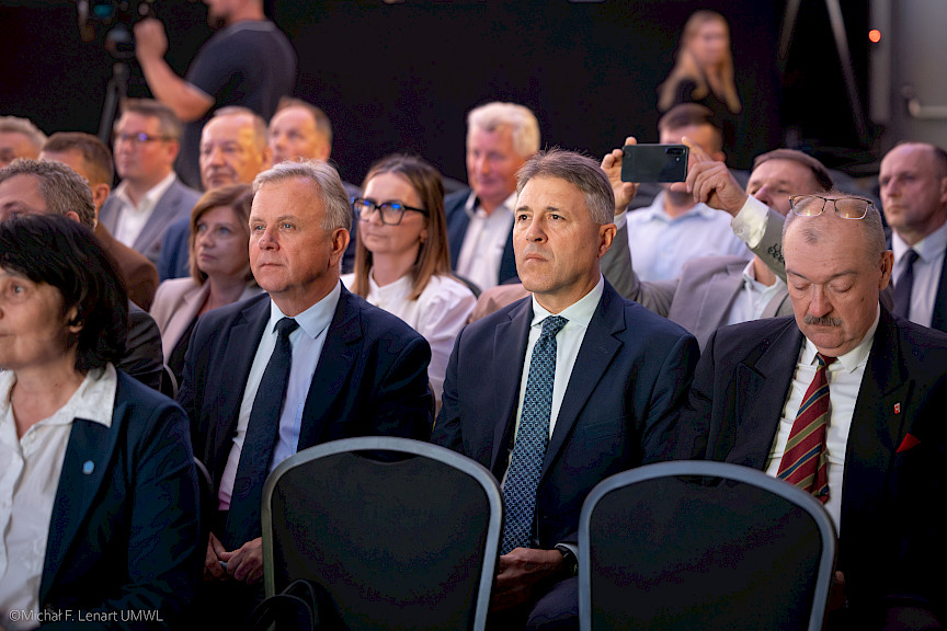 Ujęcie na część uczestników wydarzenia siedzących na sali.