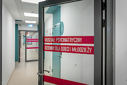 Ujęcie na otwarte przeszklone drzwi szpitalne.