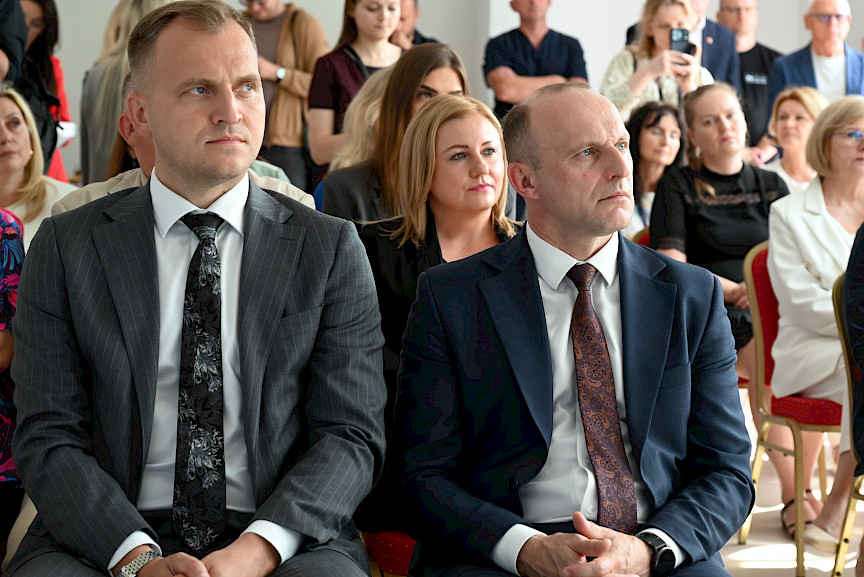 Ujęcie na uczestników wydarzenia siedzących na krzesłach.