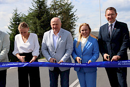 Marszałek Województwa Lubelskiego Jarosław Stawiarski, Dyrektor Departamentu Zarządzania Programami Regionalnymi Anna Brzyska, Radny Sejmiku Województwa Lubelskiego Paweł Kurek przecinają wspólnie taśmę otwierającą drogę. 