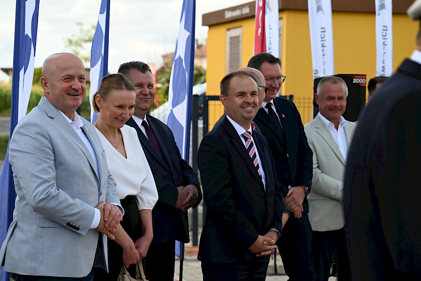 Zdjęcie kilku osób stojących na placu i uśmiechających się na czele z Marszałkiem Jarosławem Stawiarskim.