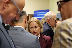 Ujęcie kilku osób rozmawiających ze sobą na korytarzu szpitala. Na wprost Dyrektor Departamentu Zarządzania Programami Regionalnymi Anna Brzyska.