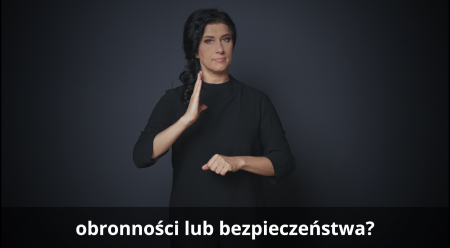 Kobiata, tłumaczka  polskiego języka migowego miga, na dole obrazu napis 