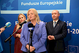 Przedstawicielka Komisji Europejskiej Elżbieta Gajeska wypowiada się do mikrofonów. Za nią stoi Wicemarszałek Województwa Lubelskiego Piotr Breś oraz Dyrektor Anna Brzyska.