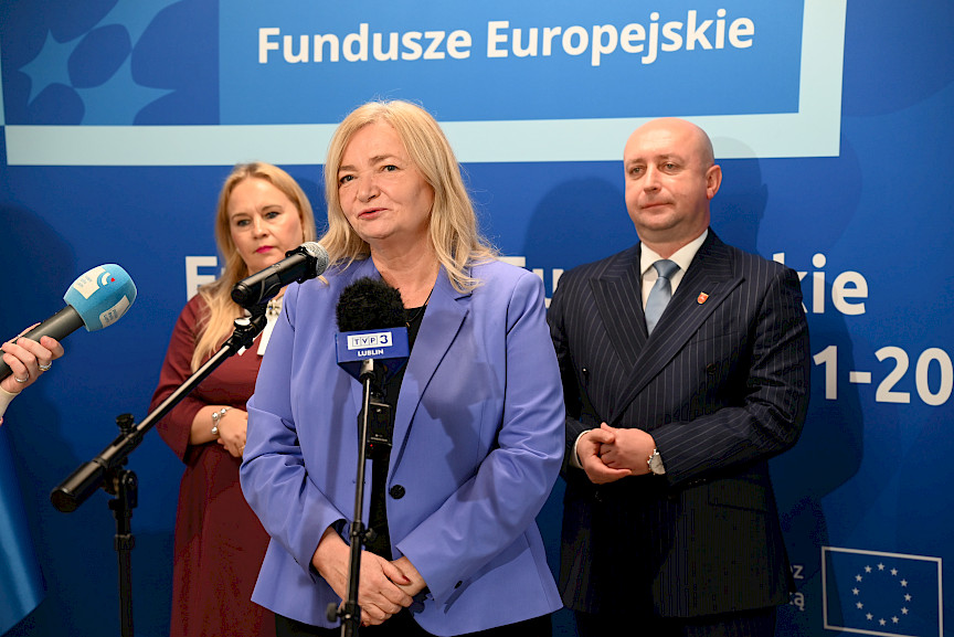 Przedstawicielka Komisji Europejskiej Elżbieta Gajeska wypowiada się do mikrofonów. Za nią stoi Wicemarszałek Województwa Lubelskiego Piotr Breś oraz Dyrektor Anna Brzyska.