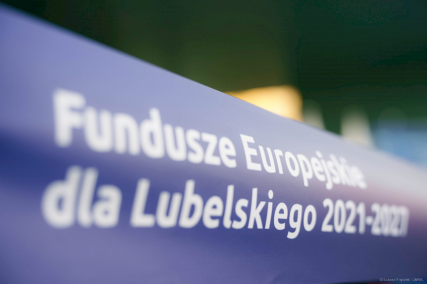 Niebieska taśma z białym napisem Fundusze Europejskie dla Lubelskiego 2021-2027.