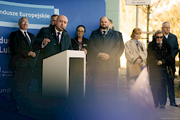Wicemarszałek Województwa Lubelskiego Piotr Breś wypowiada się przed budynkiem do mikrofonu do uczestników wydarzenia. 