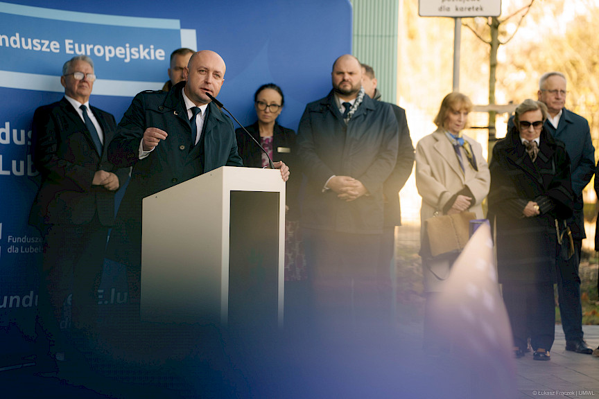 Wicemarszałek Województwa Lubelskiego Piotr Breś wypowiada się przed budynkiem do mikrofonu do uczestników wydarzenia. 