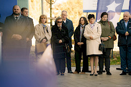 Ujęcie kilku osób stojących przed budynkiem.