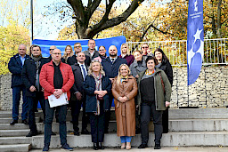 Zdjęcie grupowe uczestników wydarzenia zrobione na dworze. 
