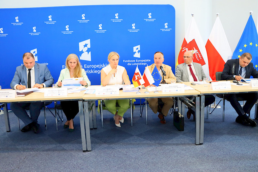 Sześć osób (kobiet i mężczyzn) za stołem prezydialnym